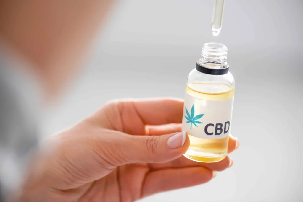 A woman is checking the expiry date of CBD oil bottle.