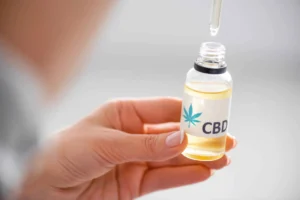 A woman is checking the expiry date of CBD oil bottle.
